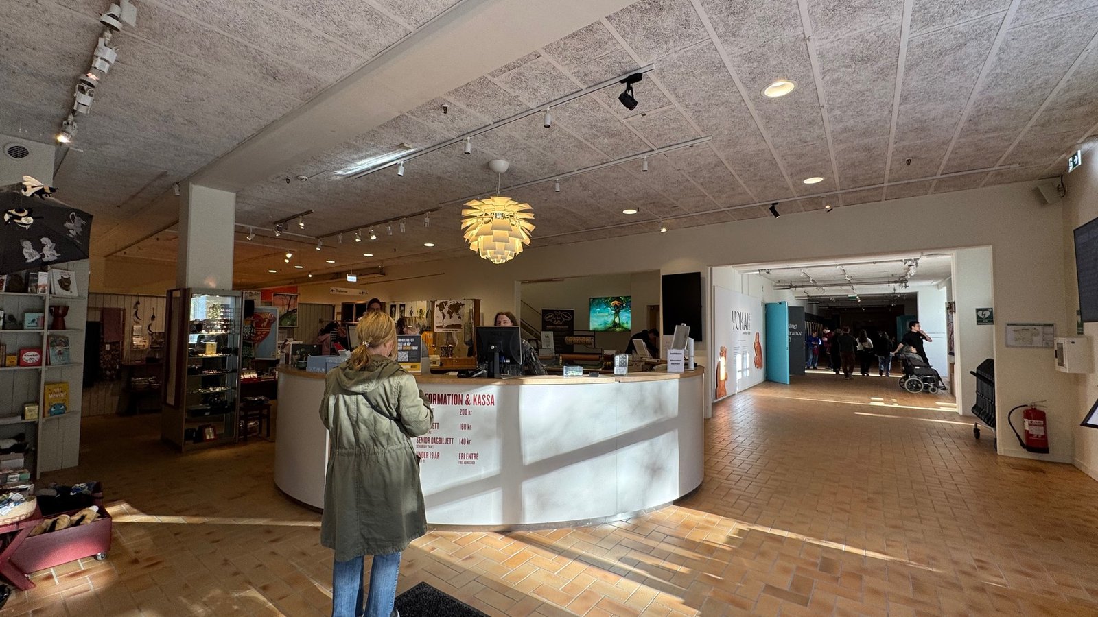 The bright entrance hall with the reception desk and shop at Etnografiska museet.