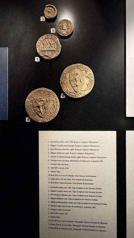 Display case of medieval royal seals and coats of arms, including Stockholm's oldest known seal from 1296.