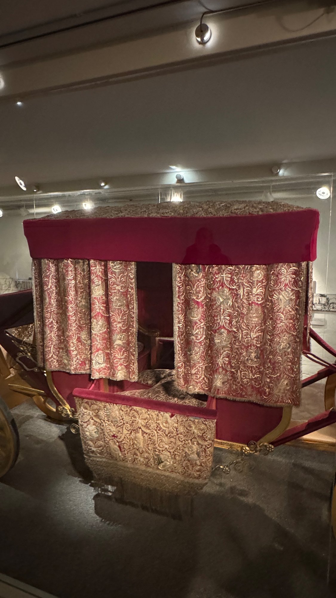 Close view of Queen Kristina's coronation coach with crimson velvet and red and gold embroidered curtains and door cloth.