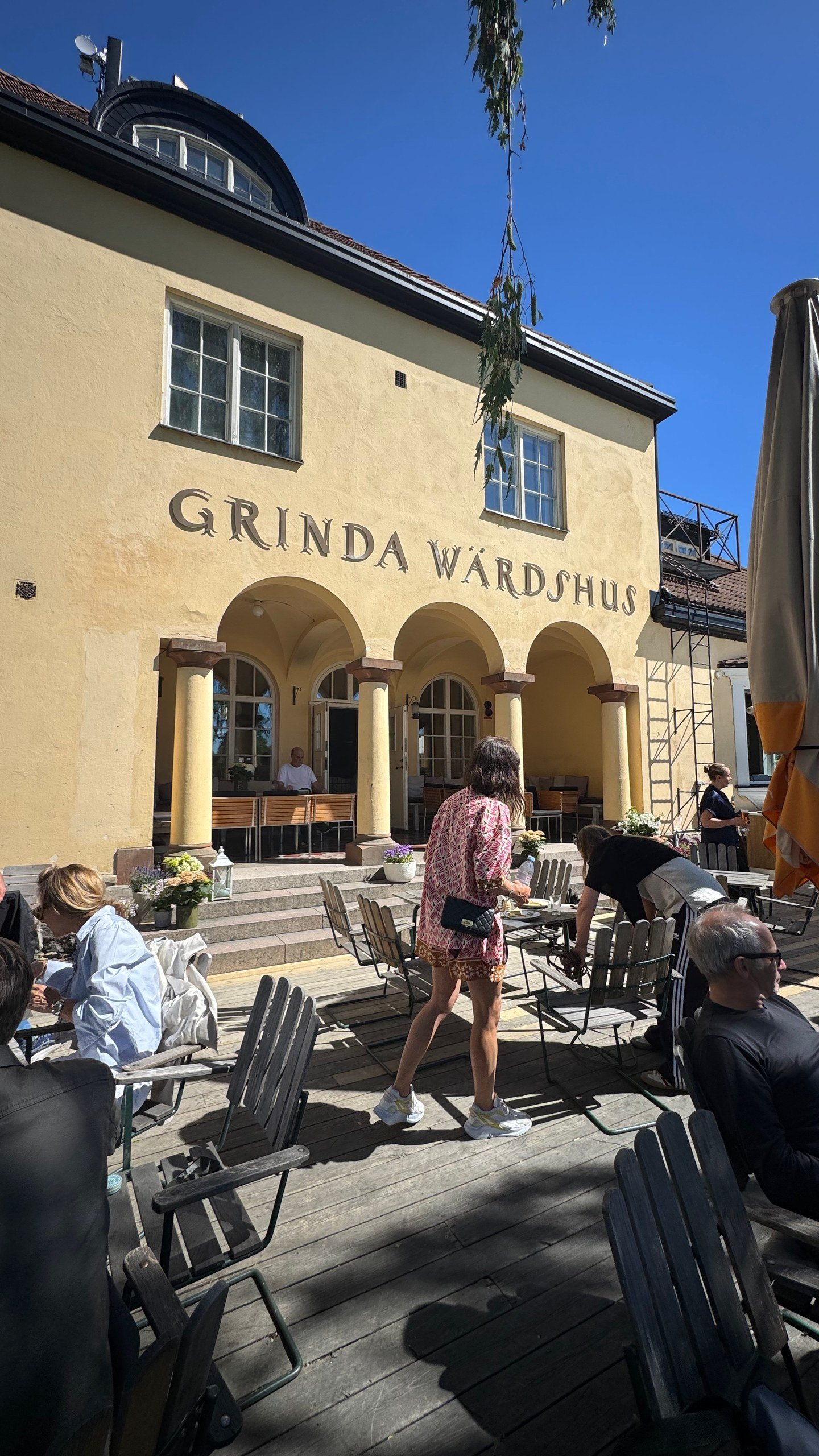 Guests sit outside Grinda Wärdshus, the yellow inn on Grinda island in the Stockholm archipelago. Photographed by Zayera Khan.