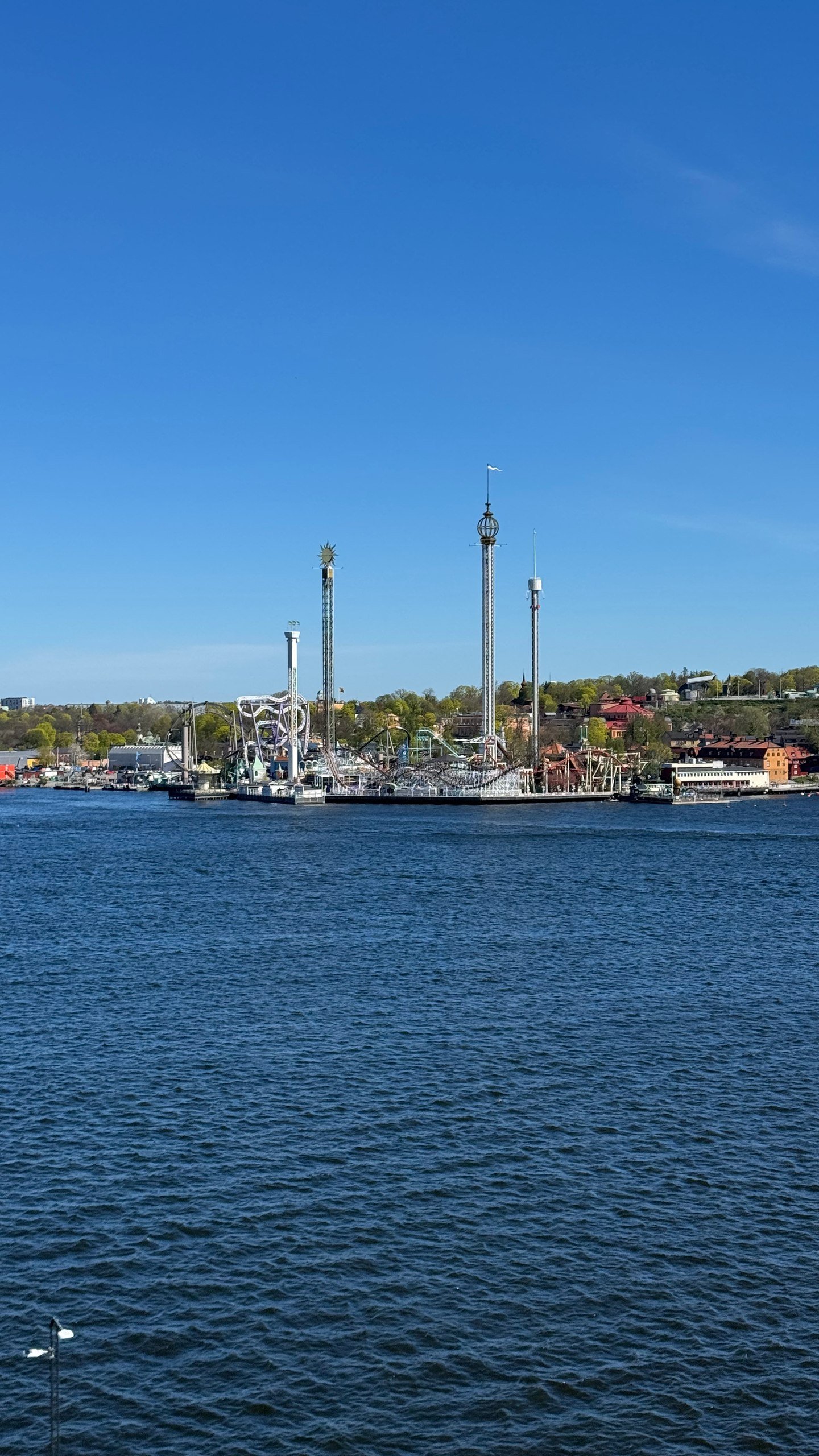 Boats moored in a small harbour lined with buildings in the Stockholm archipelago, photographed by Zayera Khan