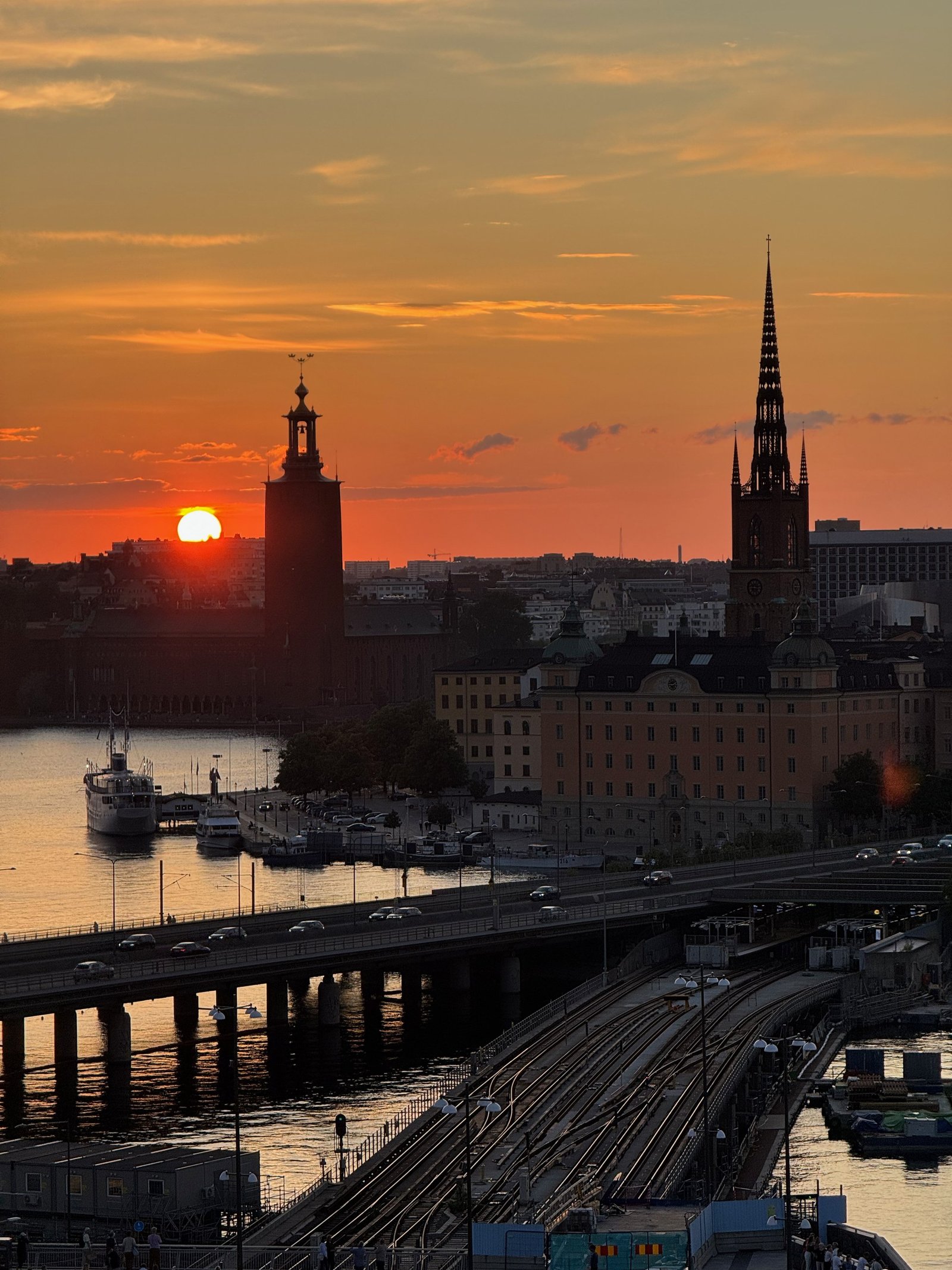 The sun sets behind Stockholm City Hall and the spires of Riddarholmen, photographed by Zayera Khan