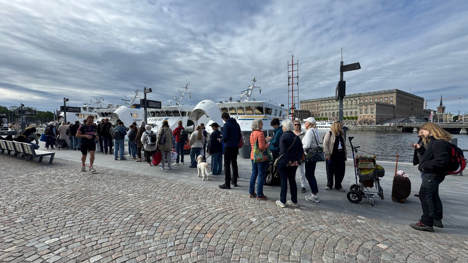 Travellers queue for boats at Strömkajen, with the Royal Palace behind Travellers queue for boats at Strömkajen, with the Royal Palace behind